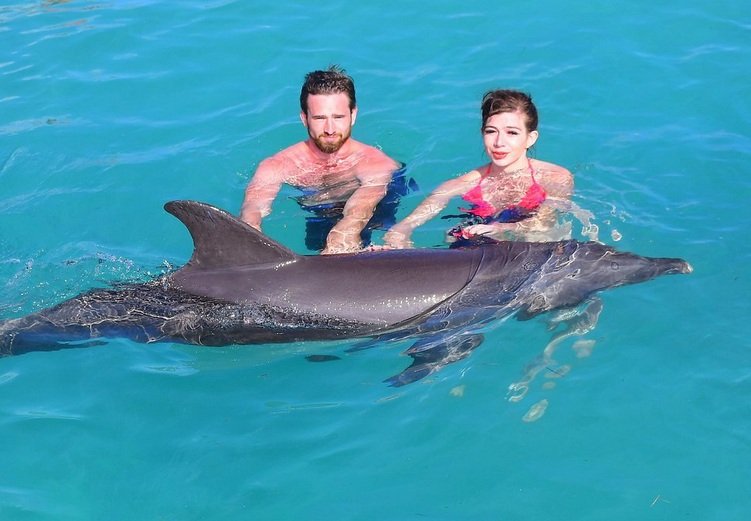 swim by couple with dolphins